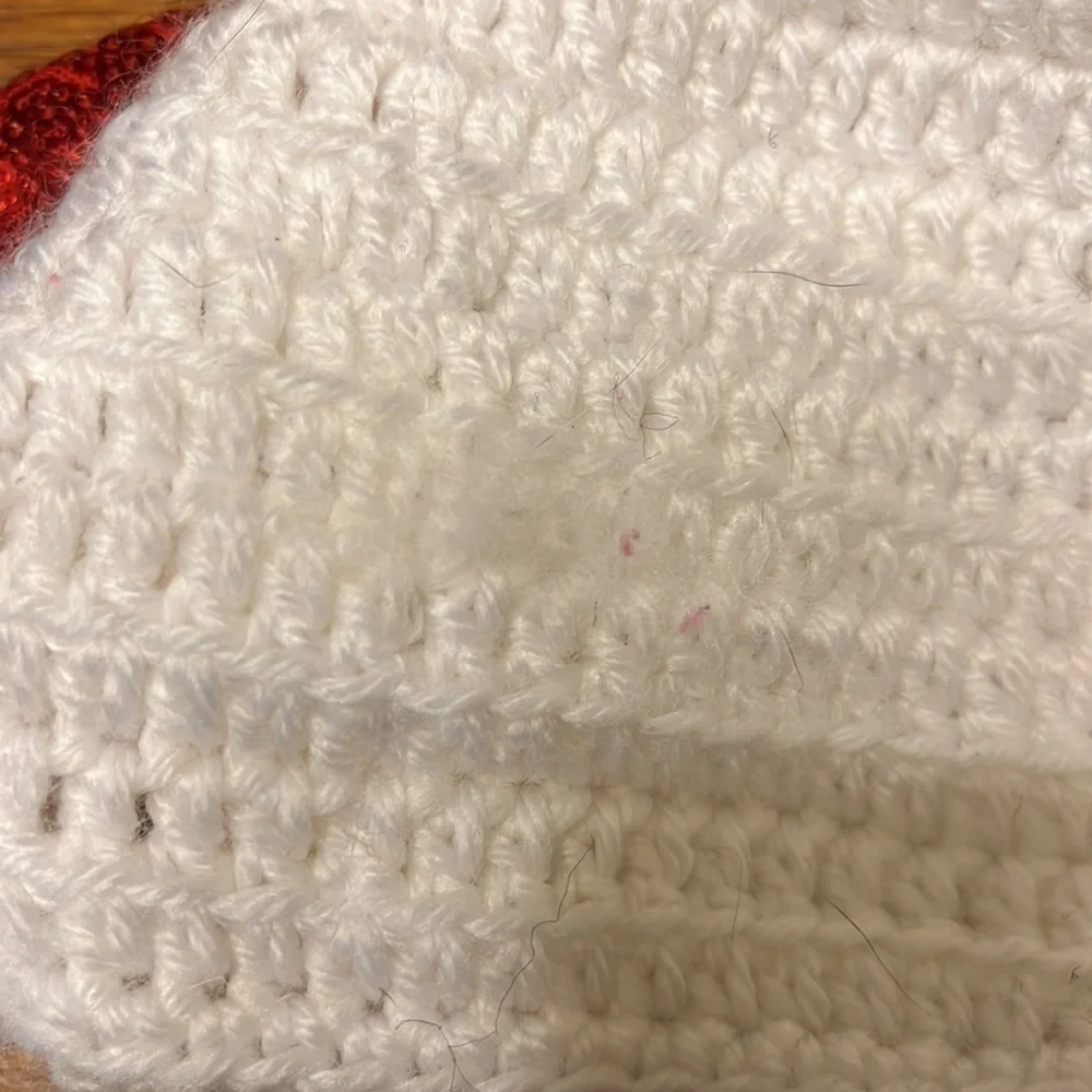 White crocheted hat with red glitter bow. Infant size 6-12mo.